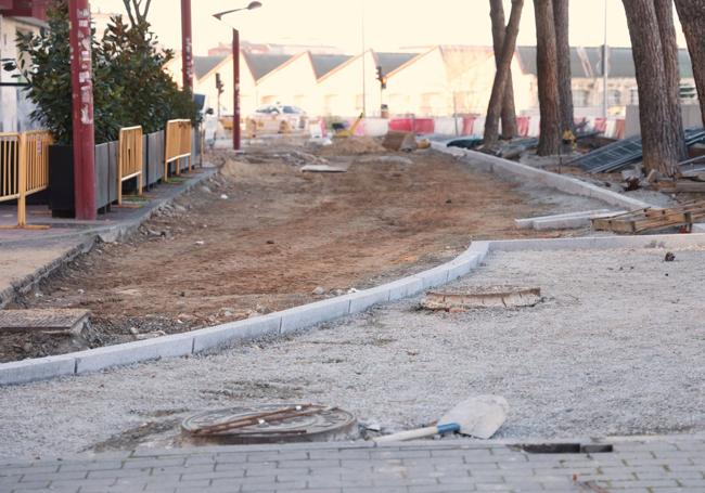 Vista del bordillo que delimitará la curva de acceso a la calle Mallorca. Al fondo, vista de los viejos talleres de Renfe.