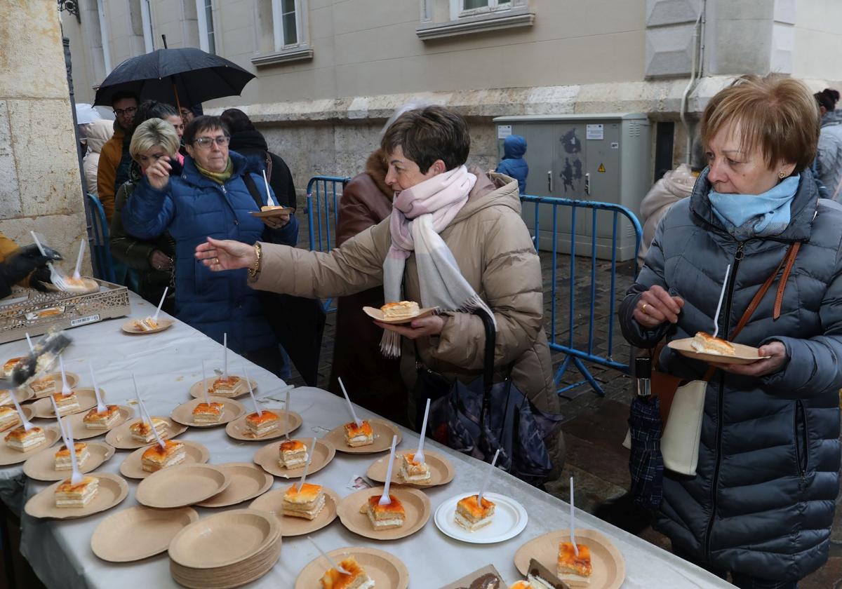 Varias personas cogen las raciones del postre de las Candelas.