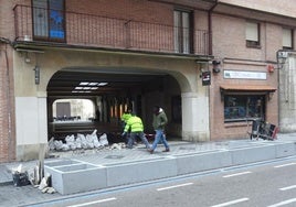 Los operarios rebajan los accesos al pasadizo de Torrecilla ante los bloques de hormigón que acogerán la bancada ajardinada.