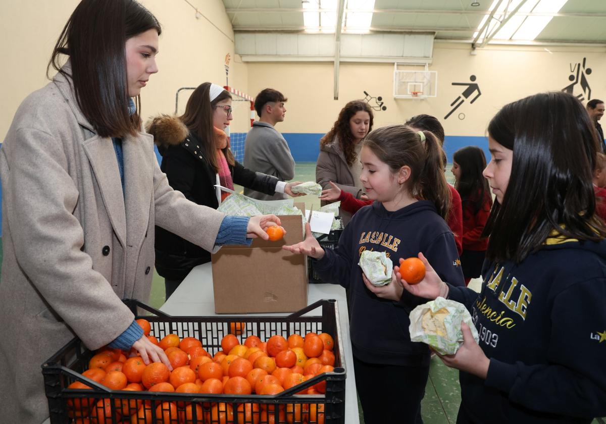 Alumnas de la Salle reciben una mandarina tras el bocadillo.