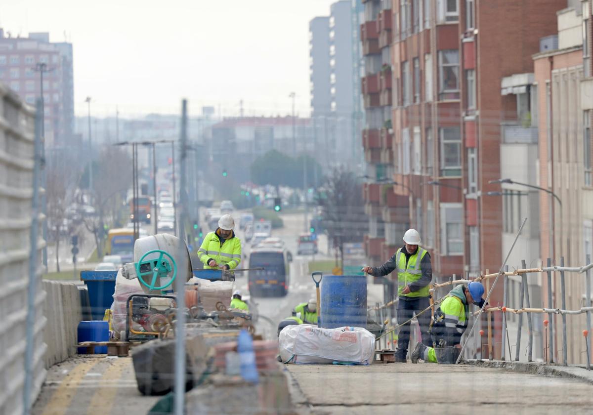 Los operarios trabajan en las defensas del carril de salida del viaducto de Arco de Ladrillo.