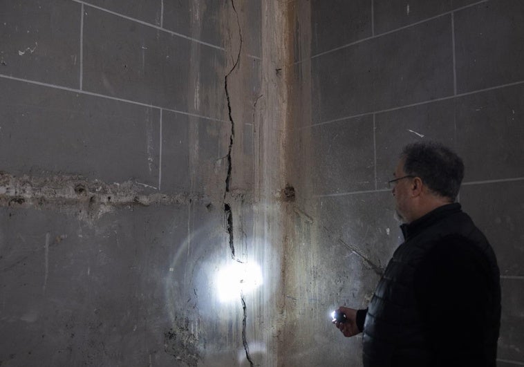 El párroco Javier Martínez observa las grietas en una de las paredes del templo renacentista de la calle Colón.