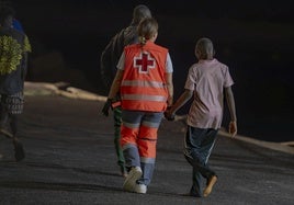 Un trabajador de la Cruz Roja atiende a un menor migrante en el puerto de la isla de El Hierro, en una imagen de archivo.