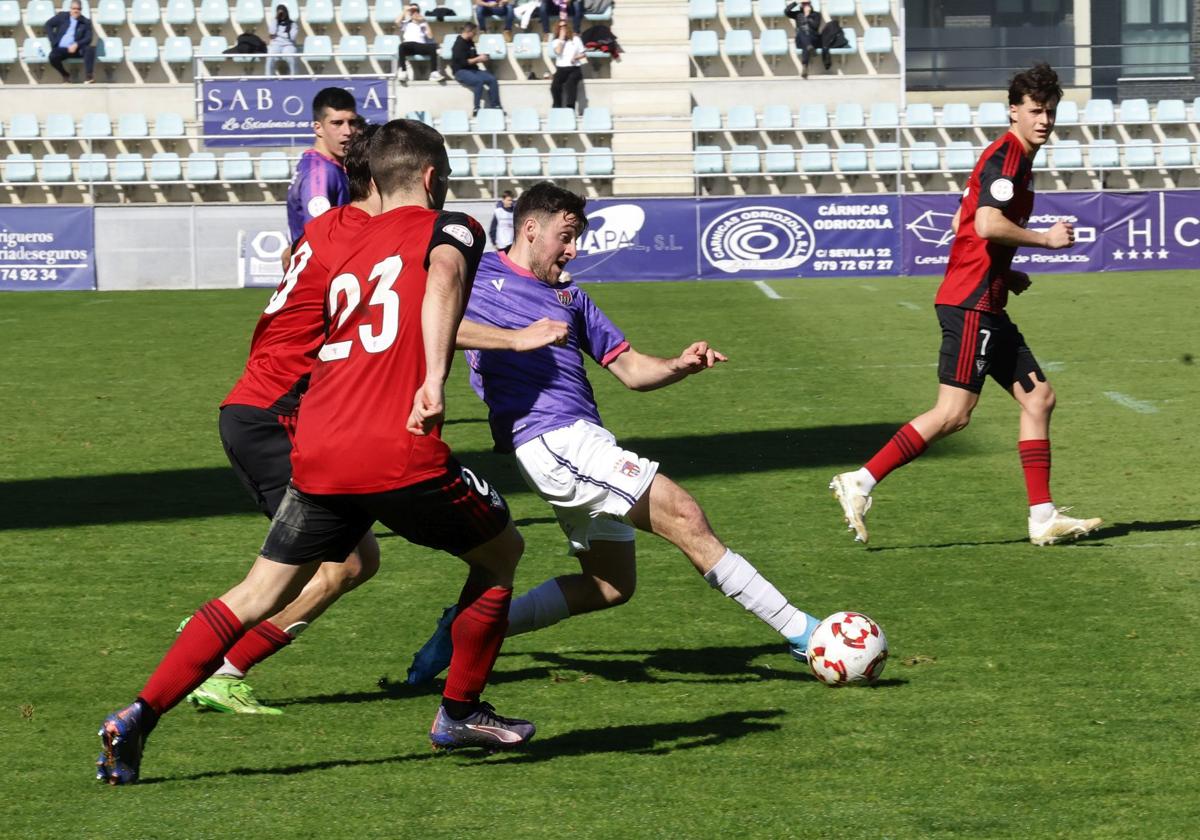 Abel de Prado, en una acción del partido ante dos rivales del Mirandés B.