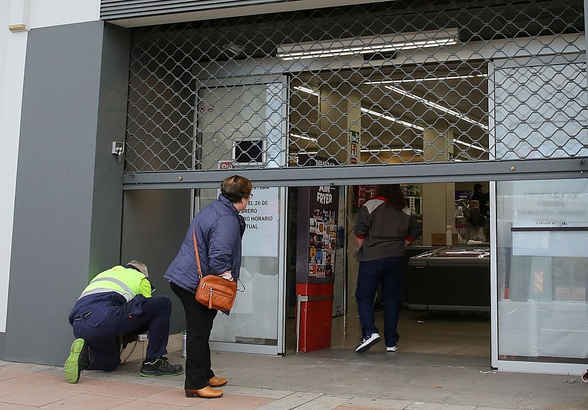 Una vecina se interesa por el interior del supermercado.