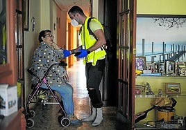 Un cuidador atiende a una mujer dependiente.