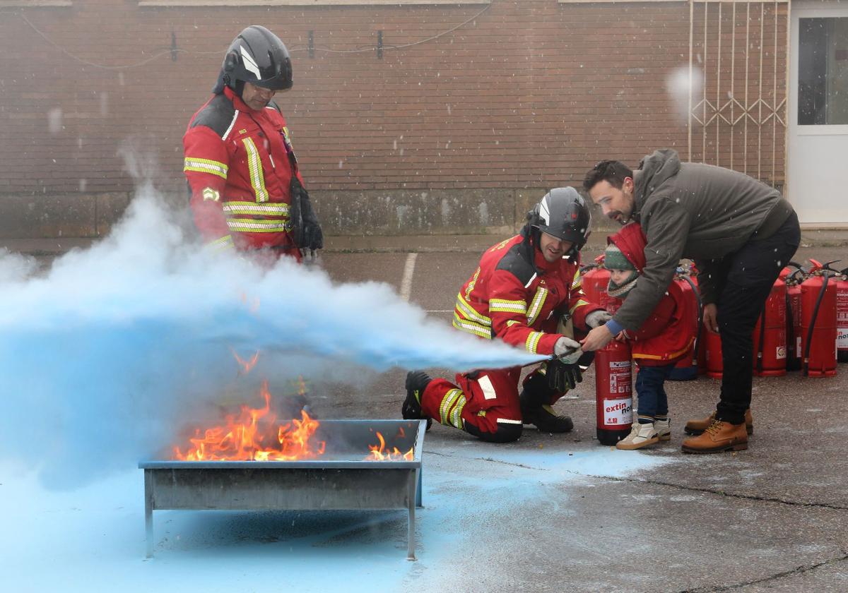 Un niño apaga un fuego controlado con un extintor, este domingo en la jornada de puertas abiertas del Parque de Bomberos.