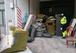 Un operario se encuentra con varios enseres en medio de una puerta de acceso a un garaje en Valladolid.