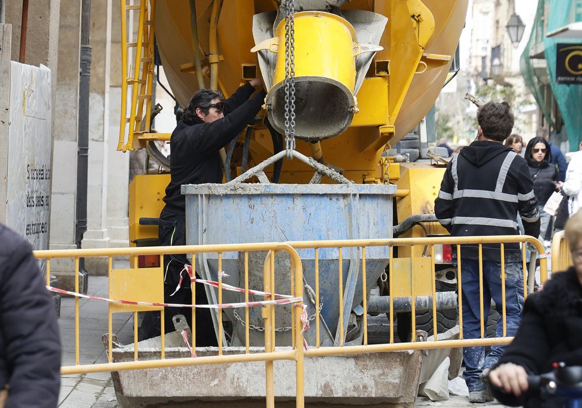 Un camión descarga material en la obra de rehabilitación de un edificio en la Calle Mayor.