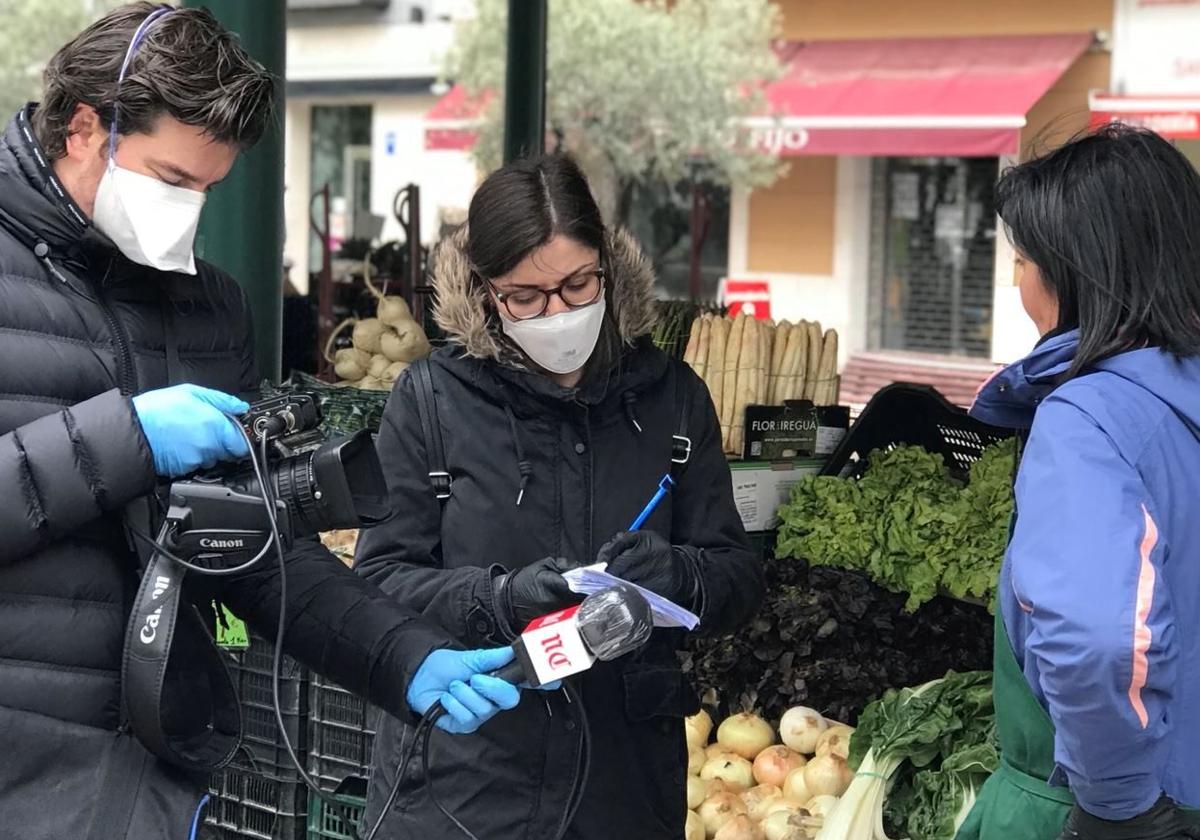 Los periodistas de El Norte Eva Esteban y Rodrigo Ucero entrevistan a una trabajadora del mercado de la Plaza España durante la pandemia.