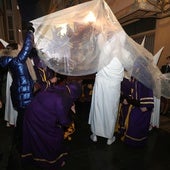 Los cofrades tratan de cubrir con plástico el Sepulcro, en la procesión del Santo Entierro del año pasado.