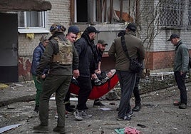Rescatistas y voluntarios evacúan a una persona herida durante un ataque con misiles rusos, en Sumy.