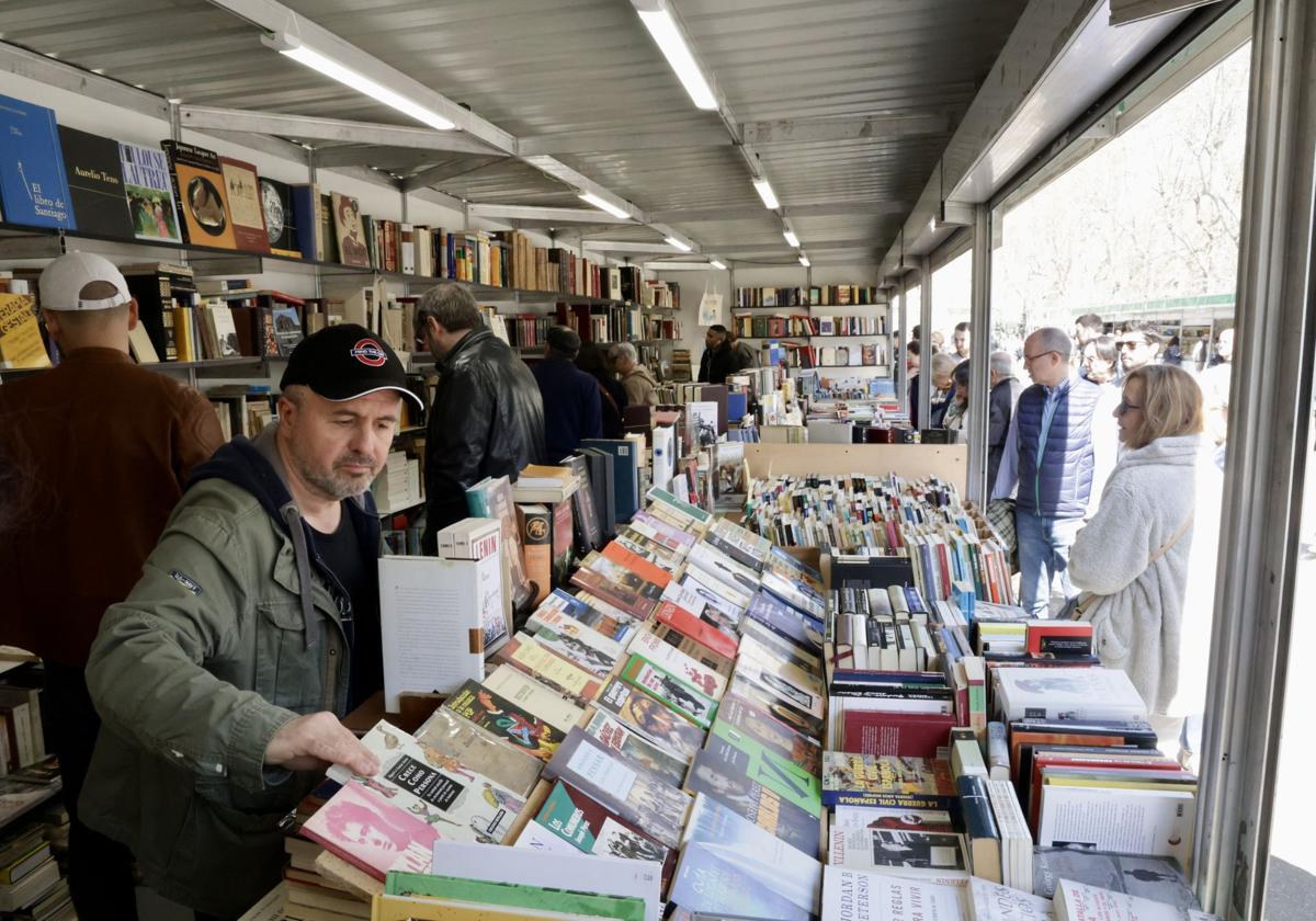El público curiosea entre las estanterías en el interior y frente al expositor de una caseta.