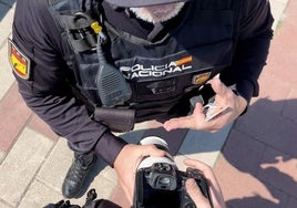 Un policía nacional agarra la cámara del fotógrafo de El Norte Alberto Mingueza evitando que realice fotografías del hallazgo de un cuerpo en el río Pisuerga.