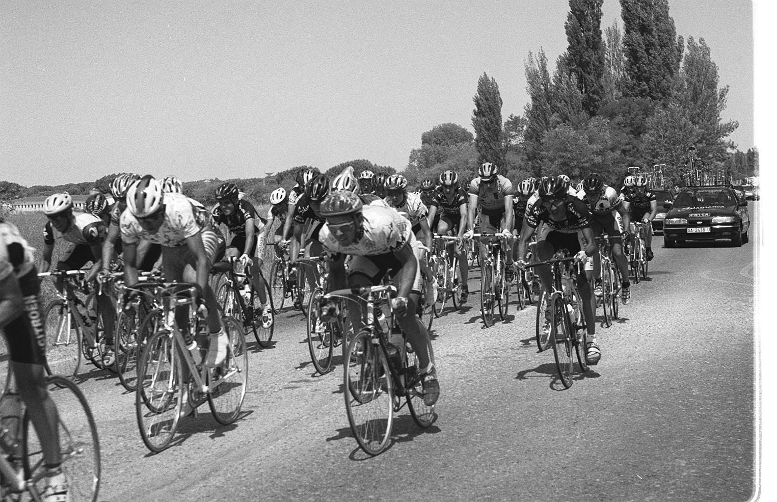 Los corredores circulan agrupados a su paso por la localidad durante la XLII Carrera del Carmen de Ciclismo de Valladolid. 11 de julio de 1999.