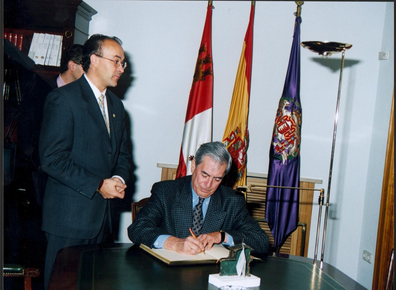El escritor Mario Vargas Llosa firma en el Libro de Honor de la Diputación de Valladolid en 1990 en presencia del presidente de la institución Ramiro Ruiz Medrano.