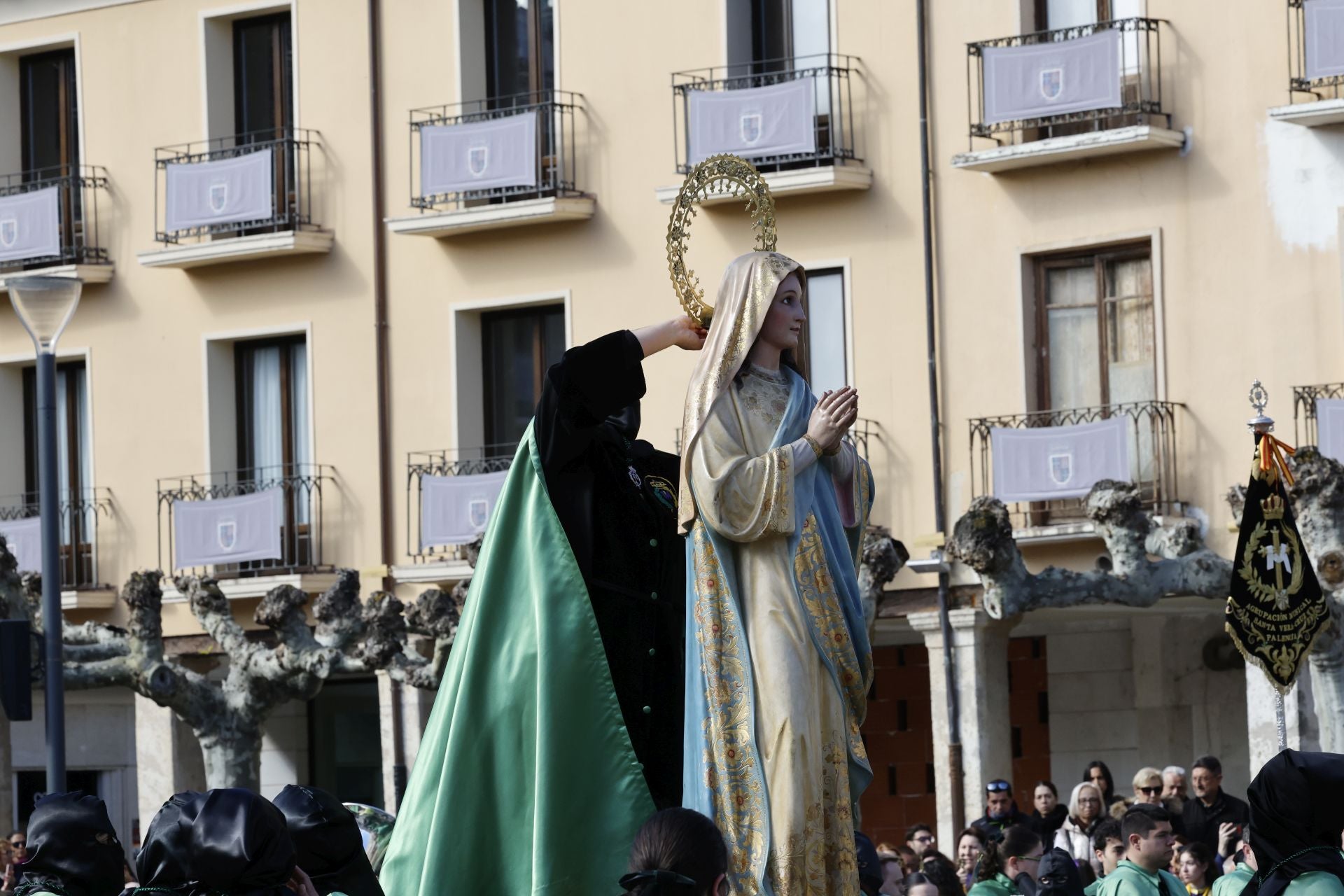Un cofrade colooca la corona a la Virgen tras quitarle el manto negro, este domingo.