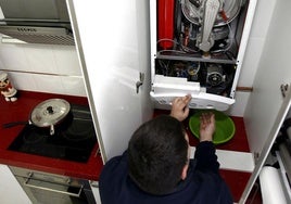 Un técnico revisa una caldera instalada en una cocina.
