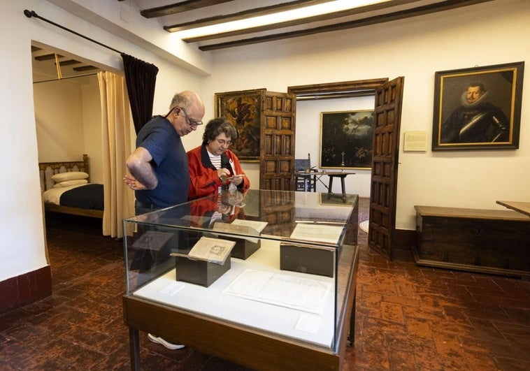 Dos visitantes al museo Casa de Cervantes, en una de las vitrinas con facsímiles de documentos históricos.