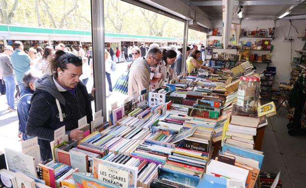 Lectores en busca de ejemplares de segunda mano en una caseta de la feria.