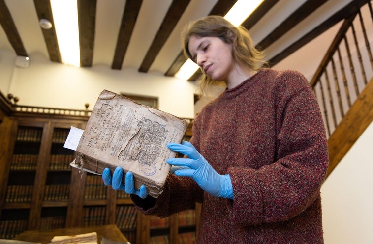 Cristina Domínguez, técnica de la biblioteca del museo, con el libro 'Teatro de los dioses de la gentilidad', de Baltasar de Victoria.