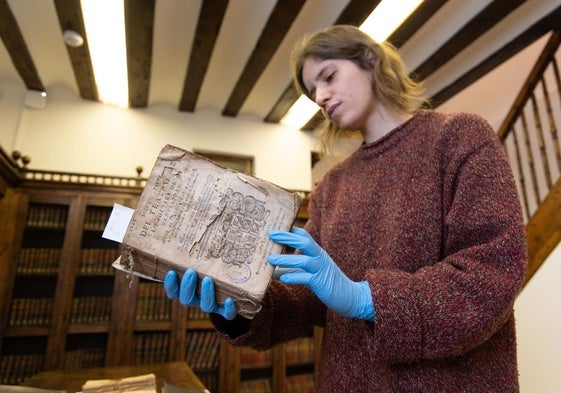 Cristina Domínguez, técnica de la biblioteca del museo, con el libro 'Teatro de los dioses de la gentilidad', de Baltasar de Victoria.