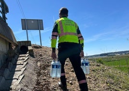 Un guardia civil lleva las botellas de agua a los pasajeros del tren.