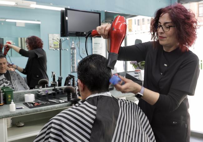 Noemí Vázquez utiliza el secador en su peluquería una vez recuperado el suministro eléctrico.