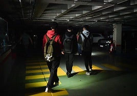 Tres jóvenes, en el aparcamiento de la Plaza Mayor de Valladolid durante el apagón.
