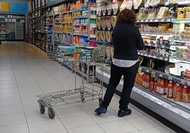 Una mujer trabaja como reponedora en un supermercado.