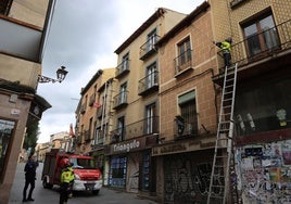 Un bombero empuja el alero que permanecía colgando.
