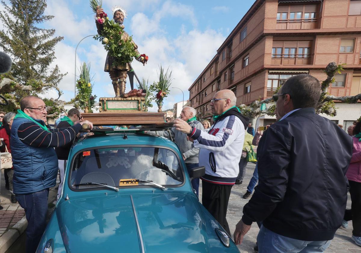 Miembros de la plataforma colocan la imagen del santo sobre un coche clásico, el año pasado.