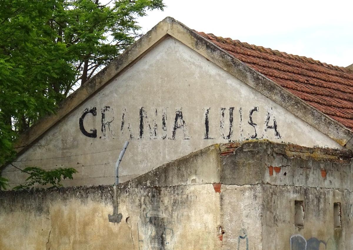 Imagen secundaria 1 - Arriba, edificaciones demolidas y en mal estado en el interior de la antigua explotación. Debajo, a la izquierda, detalle del rótulo en una esquina de la Granja Luisa. A la derecha, cristales en los muros para evitar el acceso a la parcela municipal
