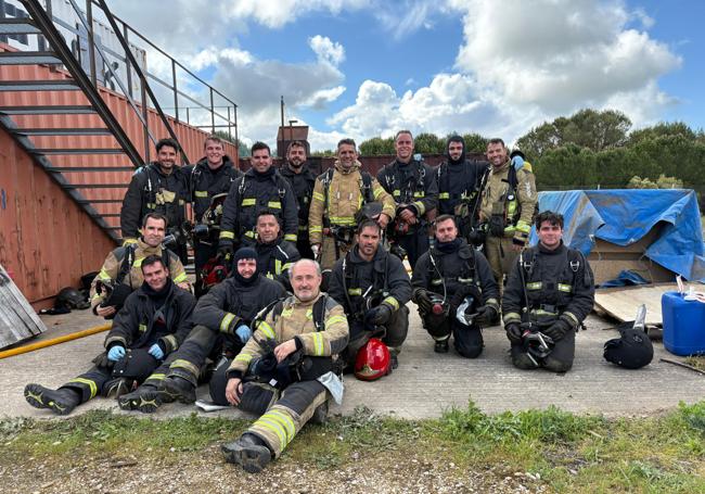 Alberto Cuadrado, en primer término, posa con los bomberos en el campo de El Rebollar.