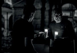 Dos personas iluminadas por la luz de las velas al caer la noche durante el apagón eléctrico del lunes 28 de abril.