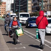 Ciclistas urbanos y un usuario de patinete eléctrico circulan por Isabel la Católica.
