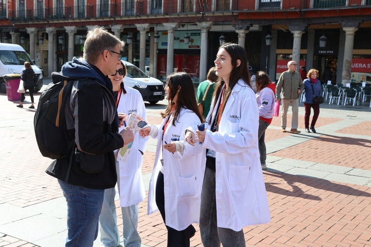 Estudiantes de enfermería conversan con los ciudadanos que se acercan al puesto instalado en la Plaza Mayor de Valladolid.