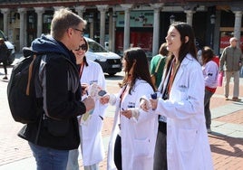 Estudiantes de enfermería conversan con los ciudadanos que se acercan al puesto instalado en la Plaza Mayor de Valladolid.
