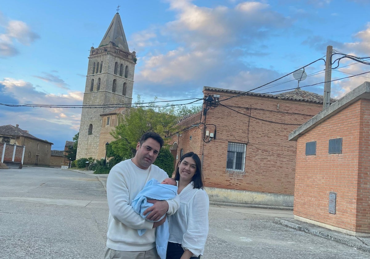 Jorge y Alicia, con su recién nacido, con la torre de la iglesia de Gatón a sus espaldas