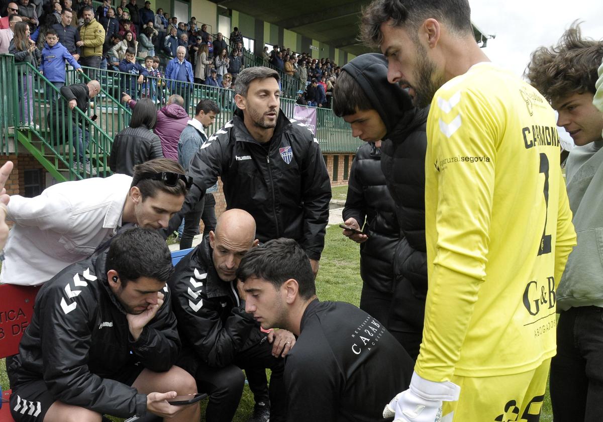 Jugadores de la Segoviana, pendientes de otro partido durante un final de temporada.