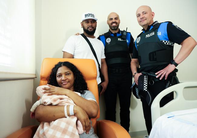 La pareja y la niña con los policías que los atendieron Ángel Barrios y Borja Sáez.