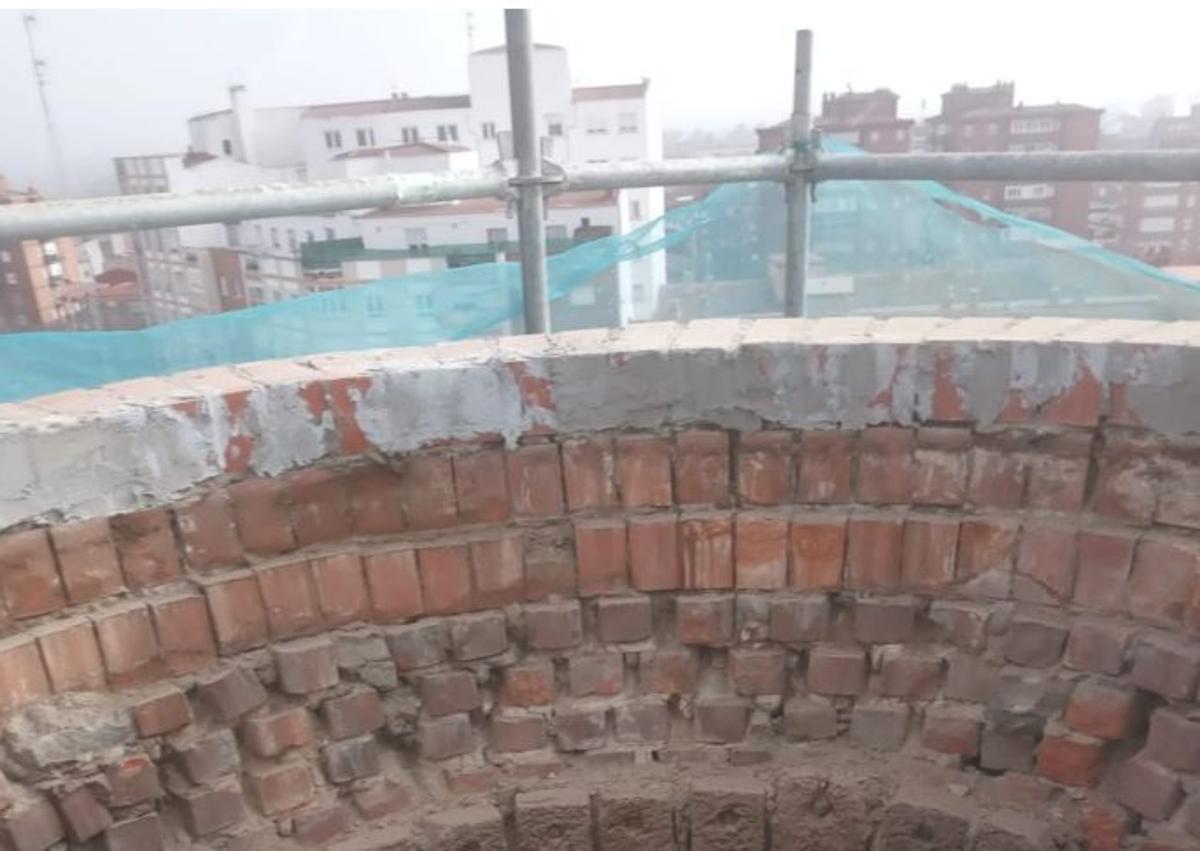 Imagen secundaria 1 - Arriba, voladura controlada de la fábrica de cervezas La Cruz Blanca en 1992. Abajo, detalle del interior de la chimenea, durante los trabajos de restauración en 2021; y la cruz blanca, logotipo de la desaparecida cerveza vallisoletana.