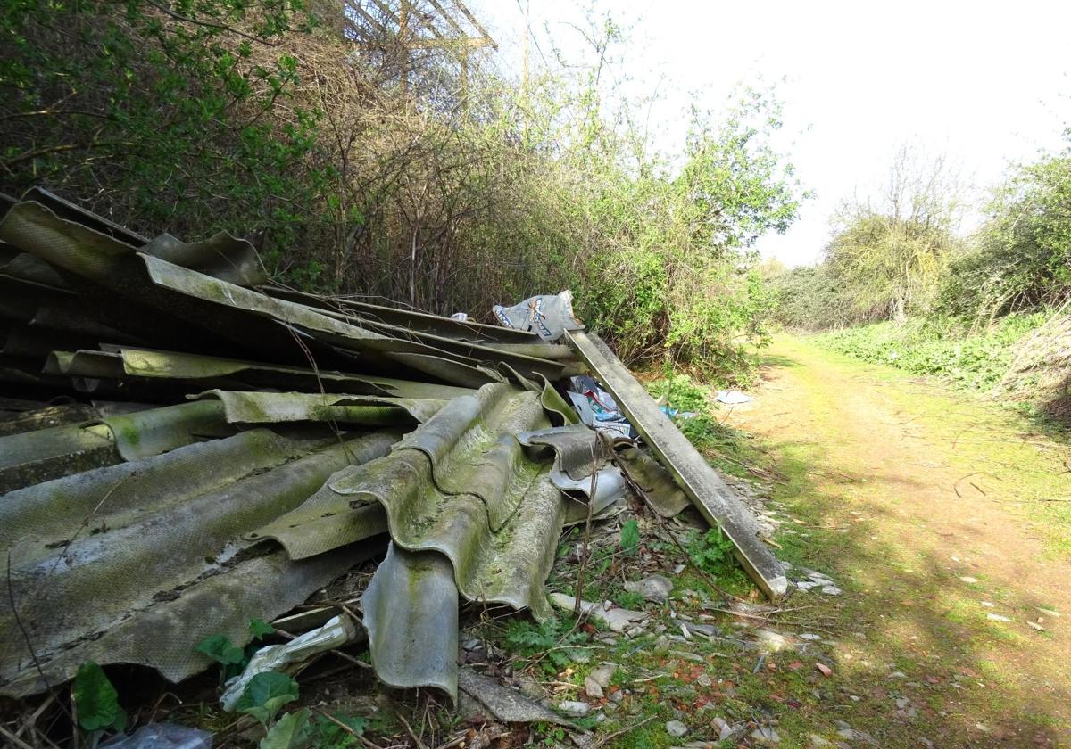 Restos de uralitas abandonadas en el camino que discurre en paralelo a la avenida de Gijón.