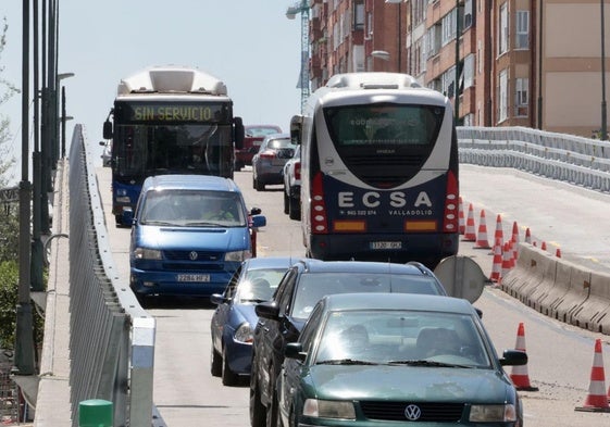 Dos autobuses, uno interurbano y otro urbano, se cruzan este miércoles a mediodía sobre el viaducto.