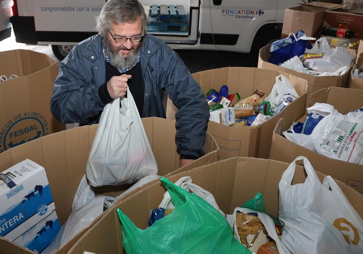 Un voluntario prepara las cajas de comida en la sede del Banco de Alimentos de Palencia.
