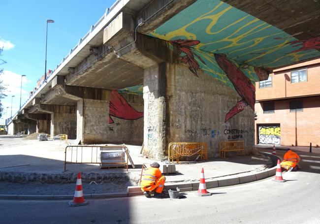 Los operarios colocan los bordillos que impedirán aparcar entre los pilares del viaducto del lado de la plaza de los Ferroviarios.
