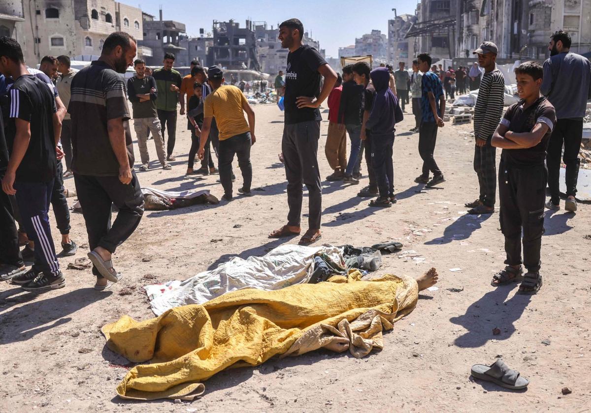 Palestinos junto a los cuerpos de las personas que murieron durante un ataque con aviones no tripulados israelíes en Jabalia, al norte de Gaza.