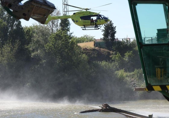 El helicóptero de Protección Civil sobrevuela el azul del río.