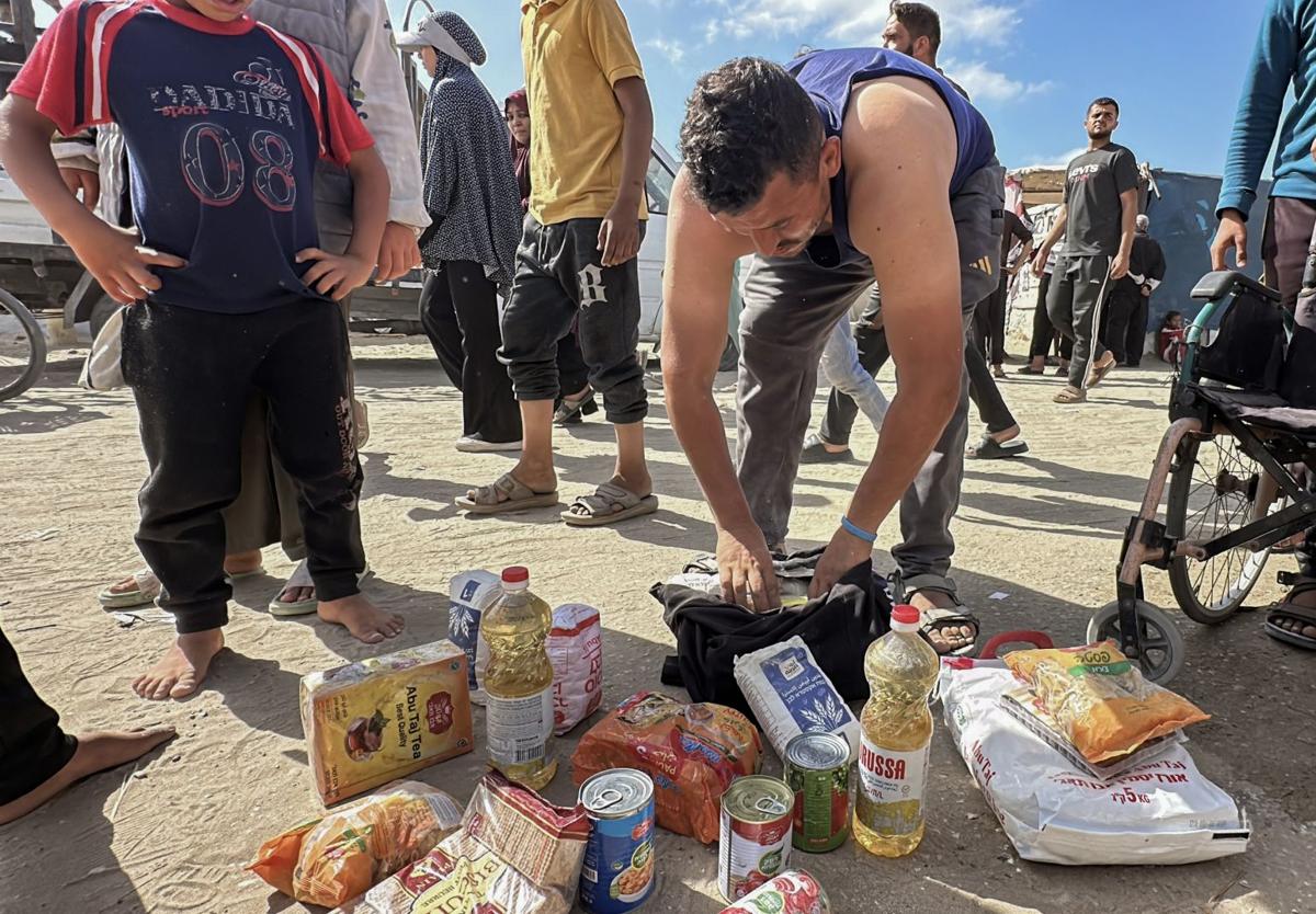 Palestinos tras recibir ayuda humanitaria de un centro de distribución en Rafah, al sur de la Franja de Gaza.