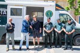 El subdelegado del Gobierno saluda a un peregrino estadounidense ante los integrantes de la OMAP.